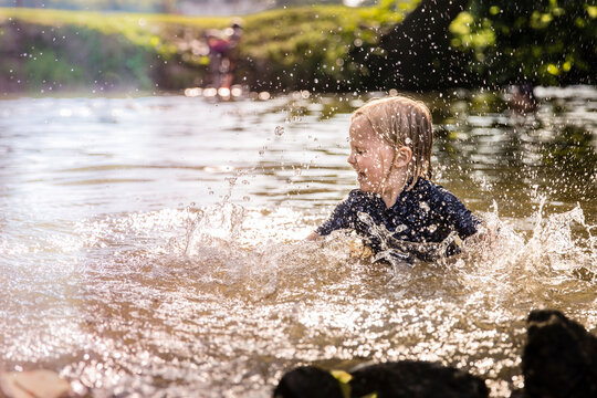 Carefree girl splashing water while playing in lake