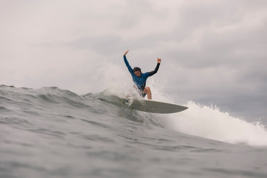 Man surfing on sea against cloudy sky