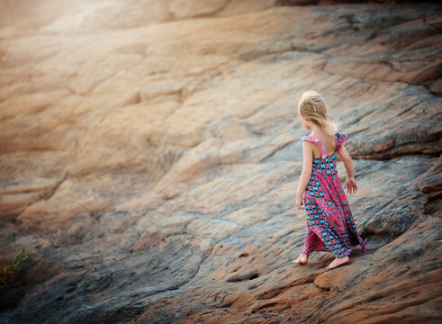 Full length of carefree girl walking on rock at beach