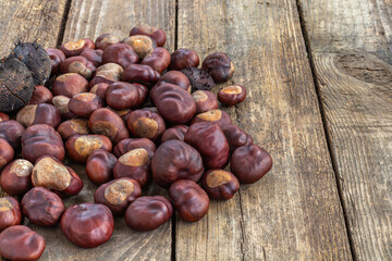 Roasted sweet chestnuts on grey rustic wooden table.