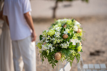 Wedding flower bouquet for wedding decor on beach at sunset on sea. marriage celebration outdoor wedding have marquee pavilion and blossom flower bouquet