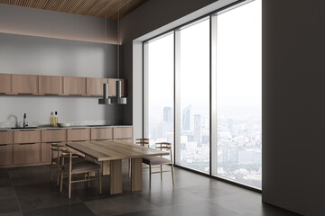Panoramic gray kitchen corner with cabinets and table