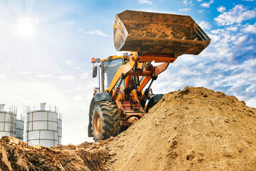 Powerful wheel loader or bulldozer working on a quarry or construction site. Loader with a full...