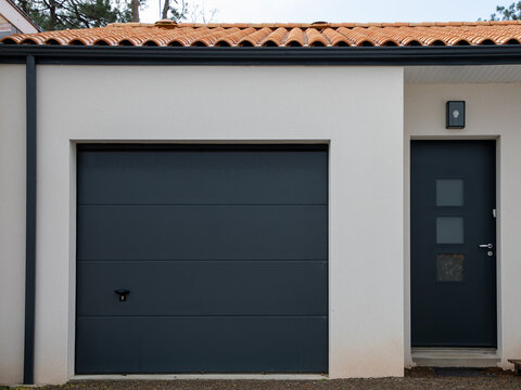 Modern White House With Grey Garage Door Of Suburb Home Entrance