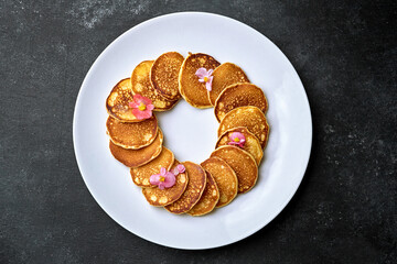 Fried pancakes on a white plate, top view