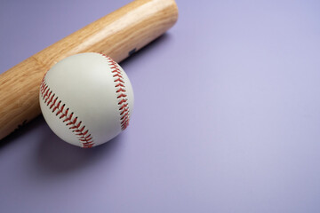 Close up baseball and baseball bat on purple table with copy space background, sport concept