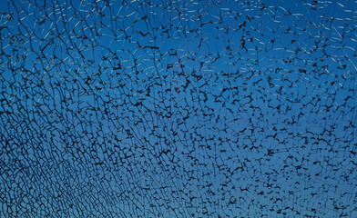 Dark blue broken cracked shattered window glass with black cracks