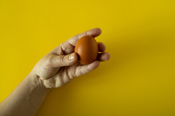 Fototapeta na wymiar a woman's hand holds an Easter egg between her fingers