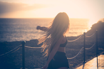Healthy sporty lifestyle people young female running and dancing happy during morning routine workout with sunlight sunrise in background. Active outdoors leisure activity woman with long hair