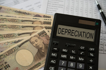 Yen money depreciation concept. depreciation word on calculator with yen money and monetary policy...