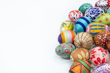 An aerial view of a collection of Easter eggs arranged on the right against a white background.