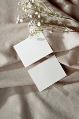 Minimal aesthetic business brand template, empty paper cards and flower on neutral beige linen textile background