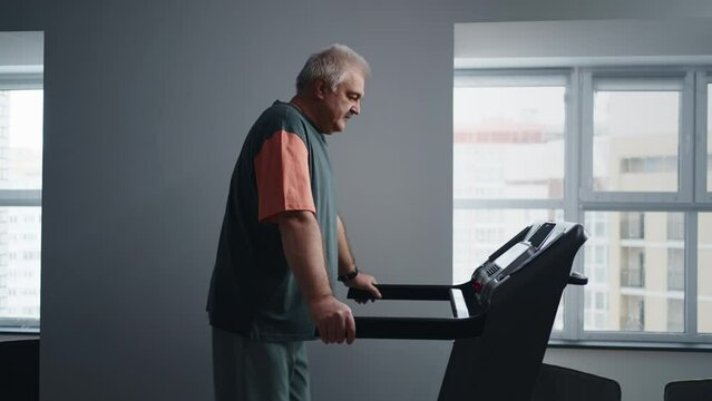 Mature Man Training On Treadmill In Rehabilitation Center Or Hospital, Working Joint After Operation