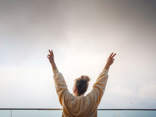woman with hands up to enjoy viewpont over Oludeniz, Turkey. Sunset, clouds, paragliders. Mount Babadag