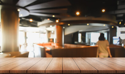 Empty wooden table top with lights bokeh on blur restaurant background.	