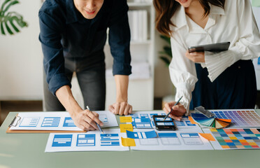 View of UI developer team brainstorming on their project with laptop, smartphone and digital tablet. Creative digital development agency..
