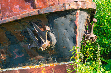 Old rusty ships lie on the riverbank. The river bank and rusting ships. Pier with old ships on the...