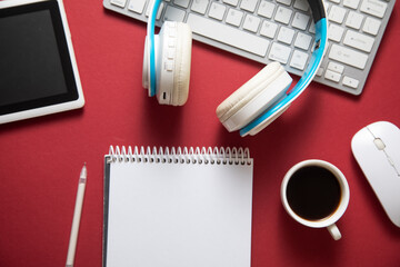 White wireless headphones and other objects on the bordeaux background.