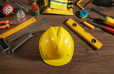 Work tools with helmet on wooden background.