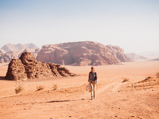 Stylish woman and the sights of the Wadi Rum desert in Jordan. Clear, sunny day. Vacation and travel concept