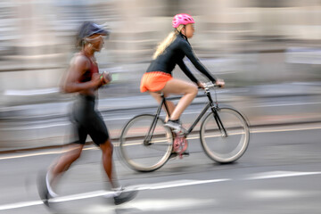 cyclists and runner on city street