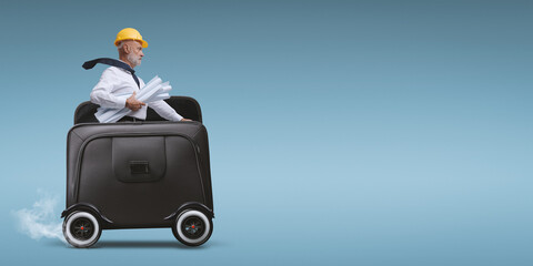 Professional architect riding a briefcase with wheels