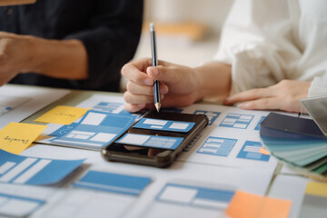 UI developer and ui designer brainstorming about mobile app interface wireframe design with...