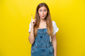 Young caucasian woman isolated on yellow background intending to realizes the solution while lifting a finger up