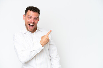 Young caucasian handsome man isolated on white background surprised and pointing side