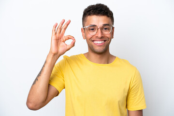 Young Brazilian man isolated on white background With glasses and doing OK sign