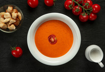 tomato cream soup in white bowl on black desk