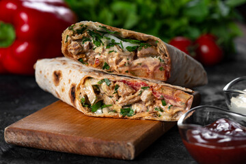 Shawarma sandwich fresh roll of, Grilled Meat and salad with white sauce on black background.