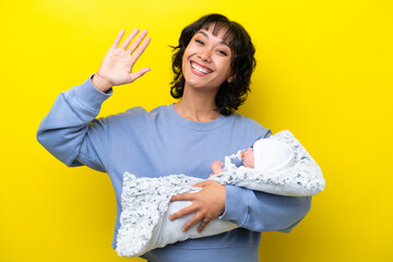Young Argentinian woman with her cute baby saluting with hand with happy expression