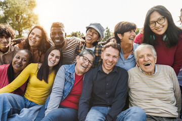 Fototapeta Group of multigenerational people smiling in front of camera - Multiracial friends od different ages having fun together - Main focus on caucasian senior faces obraz