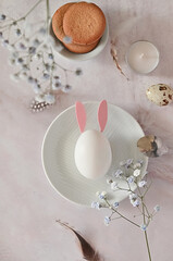 Easter composition of eggs and flowers on a light background. Easter bunny. A gentle greeting card for the Easter holiday.Top view, copy location, flat layout.