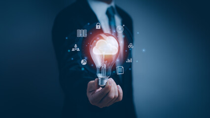 Businessman holding light bulb showing virtual cloud icon, concept of network connection on cloud computing for data discovery, data storage or digital transformation technology