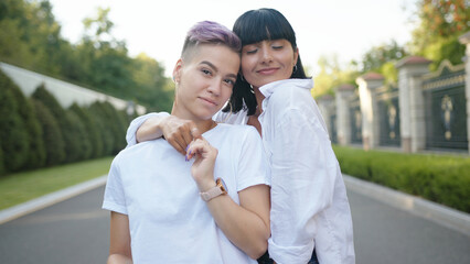 Two lesbian women standing on the street and hugging each other