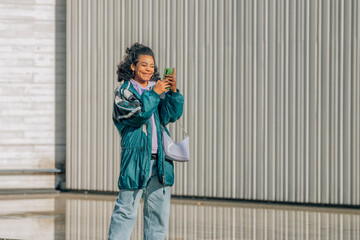fashionable urban girl on the street with mobile phone