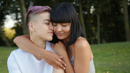 Naklejka premium Portrait of happy lesbian LGBT women in the park