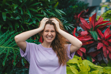 portrait of young girl on a green, natural background, eco friendly woman in a tropical park or jungle, positive lady enjoys walk at garden at summer day 