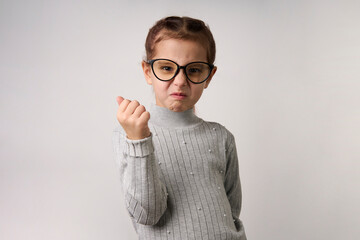 Angry girl showing her fist. Portrait of a child girl