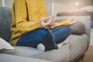 Young woman sitting on the floor and doing meditation practice mindfulness at home