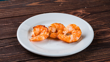 Fried shrimp in a plate on wooden table.