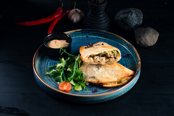 Fried cheburek with chicken, onion, sauce and herbs.