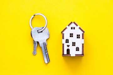 a small house on a yellow background with keys. mortgage. credit. buying a home. realtor