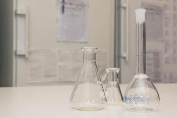 View of laboratory glassware on a white table with freezers and fridges in the background.