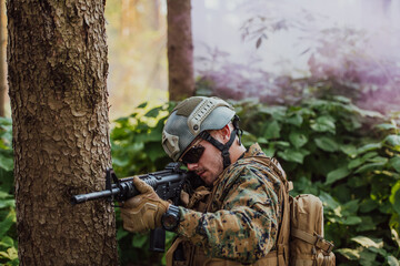 Fototapeta premium A group of modern warfare soldiers is fighting a war in dangerous remote forest areas. A group of soldiers is fighting on the enemy line with modern weapons. The concept of warfare and military