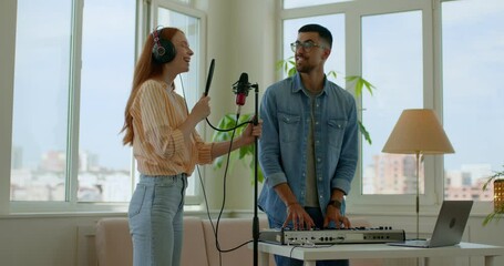 positive ginger girl and bearded handsome guy have fun at studio,enjoying singing,playing,lifestyle, entertainment slow motion Music production studio concept. results of online course.education.