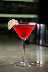 Drink Maritini cocktail with strawberry syrup and lime in a glass.