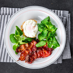 egg poached fesh breakfast bacon, green leaves salad healthy meal food snack on the table copy space food background rustic top view